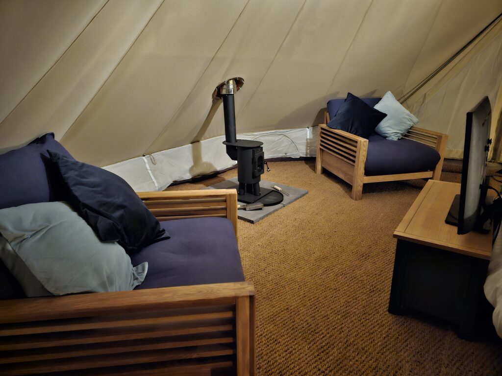 two dog friendly glamping futons in bell tent at night