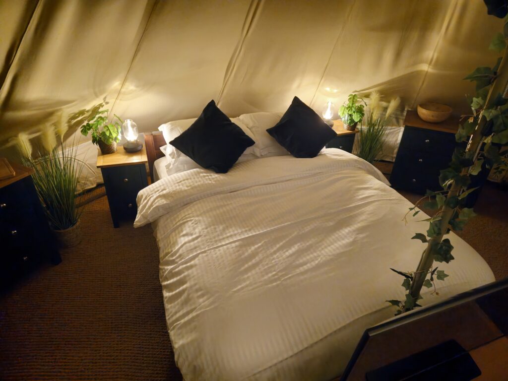 Kingsized bed in tent at night