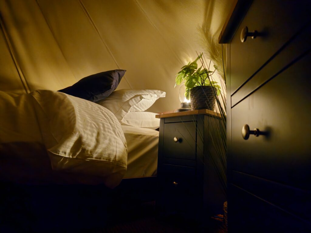 View of Bed and chest of draws at night